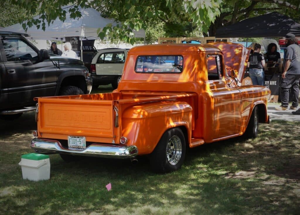 an orange truck parked in a grass field