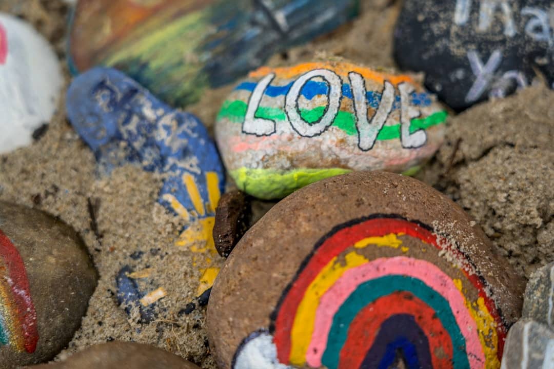 small rocks painted with peace love and rainbows